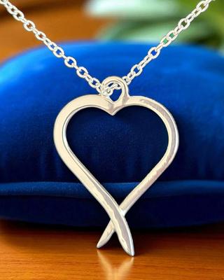 Open sterling silver heart with flowing tails